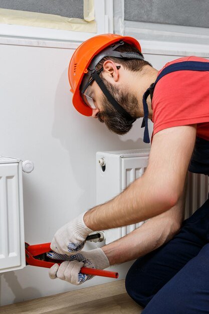 worker orange helmet installs radiators house